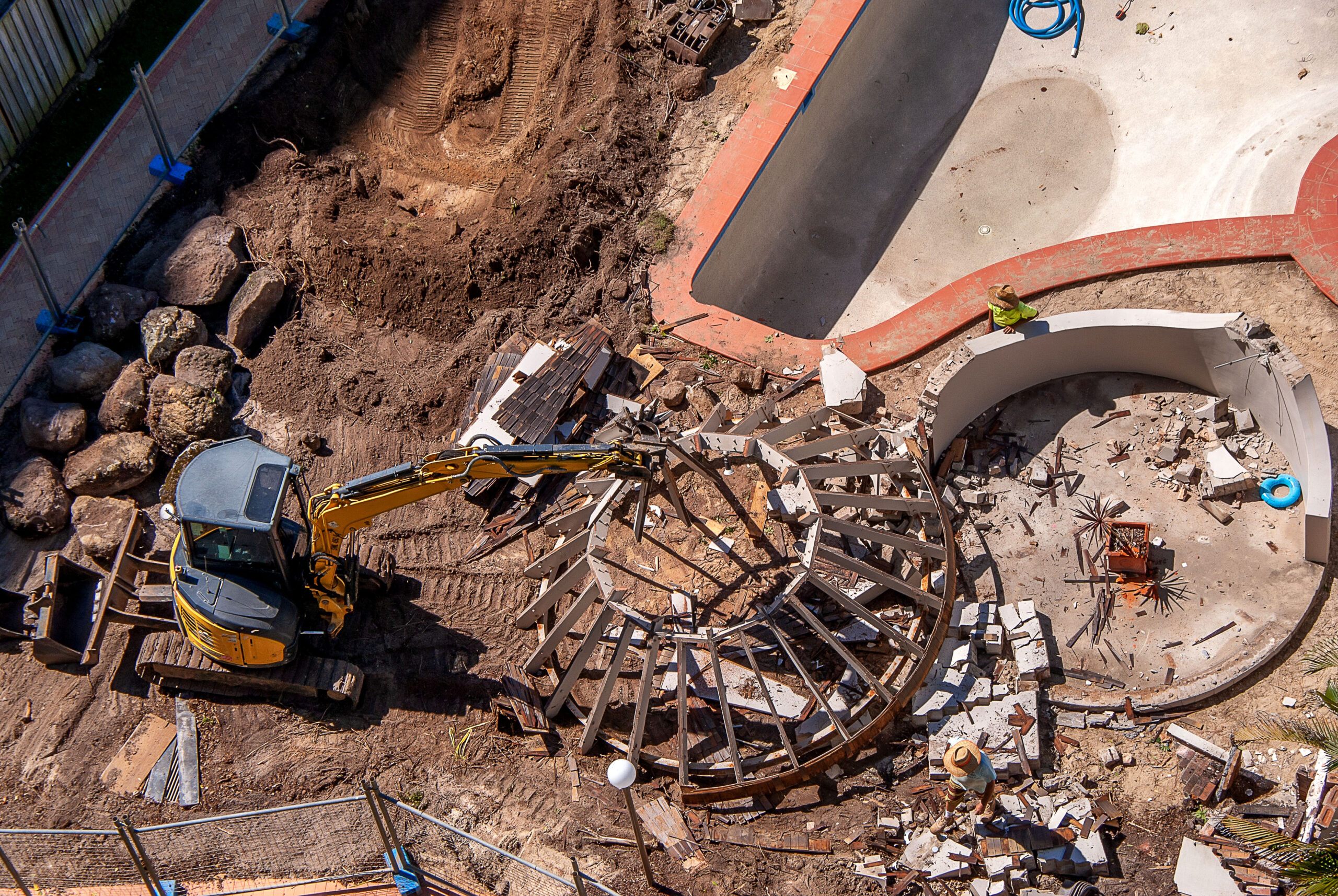 Excavator destroys old swimming pool